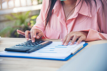 Woman Hands working home do accounting small business. Audit Businesswoman at office desk. Close up businesswoman hands audit accountant using calculator, business graph chart working at home office.