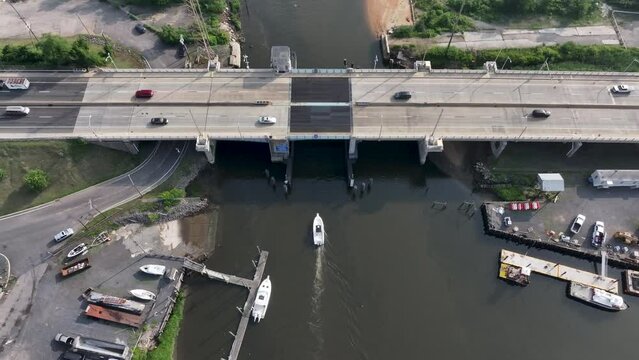Aerial view of Boat passing beneath Route 35 Bridge going over Cheesequake Creek in NJ