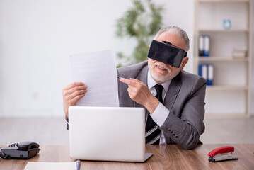 Old male employee enjoying virtual glasses at workplace