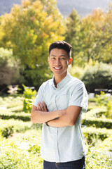 Portrait of happy asian man smiling in sunny garden