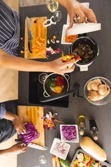 Fotobehang Midsection of diverse couple preparing meal, chopping vegetables and composting waste in kitchen © WavebreakMediaMicro