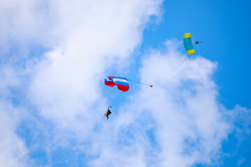 Obraz na płótnie Canvas Parachute in the sky. Skydiver is flying a parachute in the blue sky
