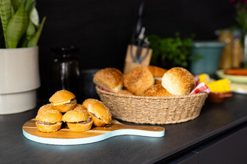 Close up of basket with rolls and mini hamburgers on countertop in kitchen