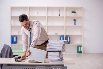 Young male employee unhappy with excessive work in the office