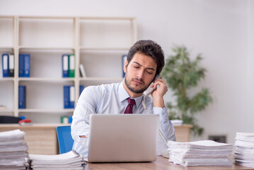 Young male employee and too much work in the office