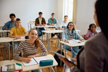 High school student and her classmates attending class in classroom.