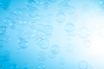Fototapeta na wymiar Beautiful Transparent Blue Soap Bubbles Floating in The Air. White Space, Abstract Fun Background, Blue Gradient Blurred Background, Refreshing of Soap Suds Bubbles Water.