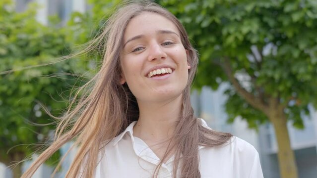 Confident corporate woman with wind-blown hair, smiling joyfully