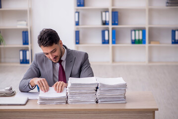 Young male employee and too much work in the office