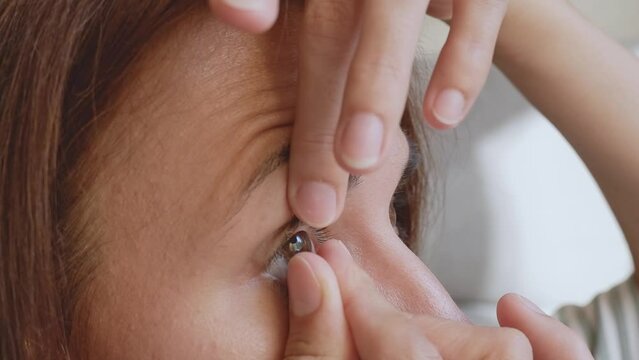 woman takes off contact lenses close-up, brown eyes