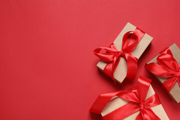 Beautiful gift boxes on red background, flat lay. Space for text