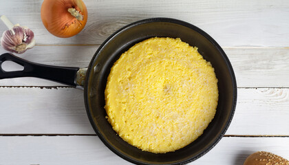 basic polenta in pan on white wooden table, authentic italian recipe, view from above