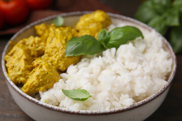 Delicious rice and chicken with curry sauce in bowl, closeup