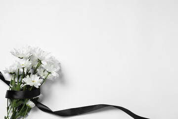 Beautiful chrysanthemum flowers and black ribbon on white background, top view with space for text. Funeral symbols - obrazy, fototapety, plakaty