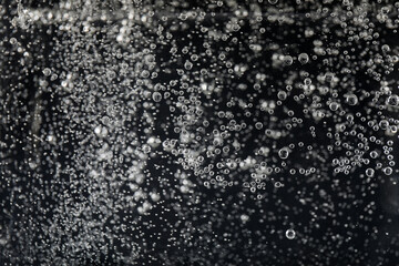 Clear soda water against black background, closeup