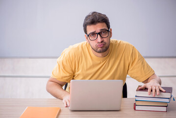 Young male student sitting in the classroom