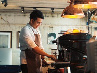 Cheerful Asian man making a coffee cup in cafe,Barista prepares coffee for the first 