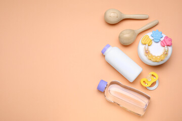 Flat lay composition with baby care products and accessories on pale orange background, space for text