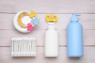 Flat lay composition with baby care products on white wooden table