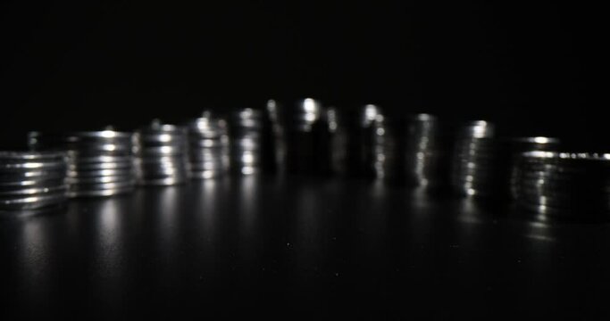 Coins are stacked on a black background. Illegal circulation of finance. Money investments and savings concept