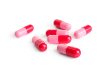 Many pink pills isolated on white. Medicinal treatment