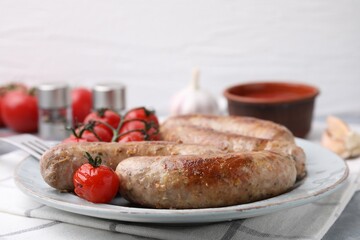 Plate with tasty homemade sausages and tomatoes on table, closeup