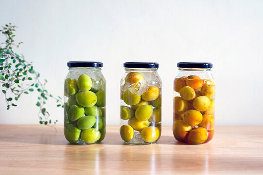 Umeshu, a Japanese liqueur made by steeping ume plums in liquor and sugar, on the table. 3 bottles of Umeshu.