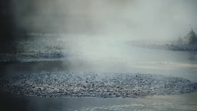 Boiling hot geothermal volcanic mud pool, closeup shot steamy lake bubbling mud and steam satisfying