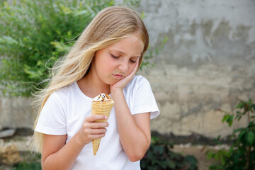 Girl has a toothache from cold ice cream.