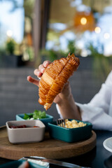 Woman ready to eat fresh baked croissant. Delicious morning breakfast with croissant