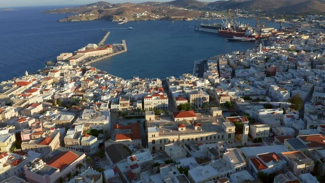 Aerial: Slow panoramic drone shot of Syros island port during sunset