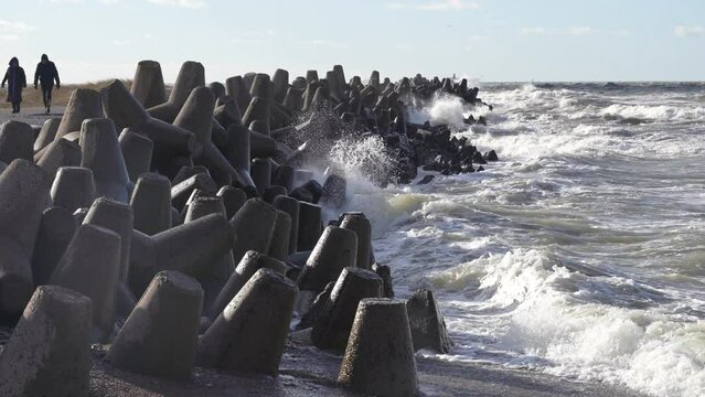 Waves crashing against breakwater consisting of gray concrete tetrapods. Liepaja, Latvia. Liepājas Ziemeļu mols
