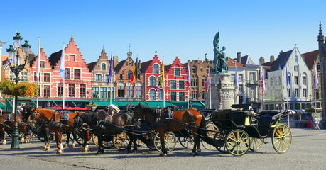 Naklejka premium Panorama von malerischem Markt in Brügge in Belgien mit mehreren Pferdekutschen vor alten Häuserfassaden