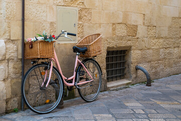 Pink bicycle parked at a side on a street