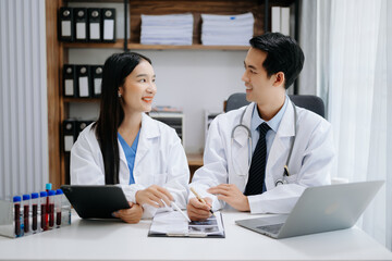 Obraz premium Medical technology network team meeting concept. Asian Doctor hand working with smart phone modern digital tablet and laptop computer with graphics chart interface,