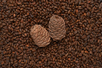 Texture raw ripe fresh brown pine nuts in shell as background, top view.