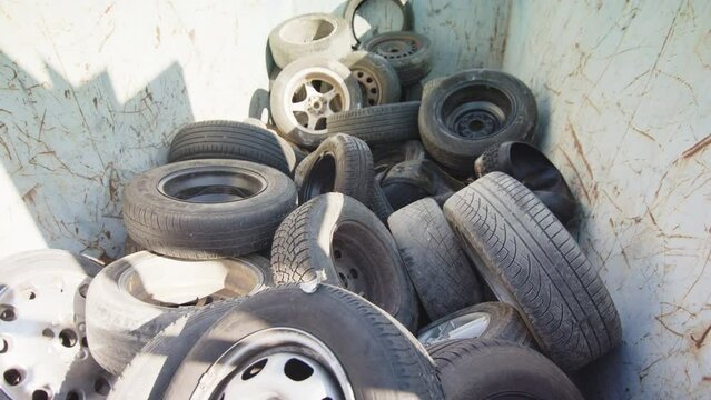 Heap of discarded and used waste tyres dumped at landfill, wide shot