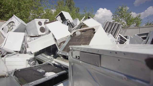Broken and discarded bulky household appliances dumped at landfill. Slider