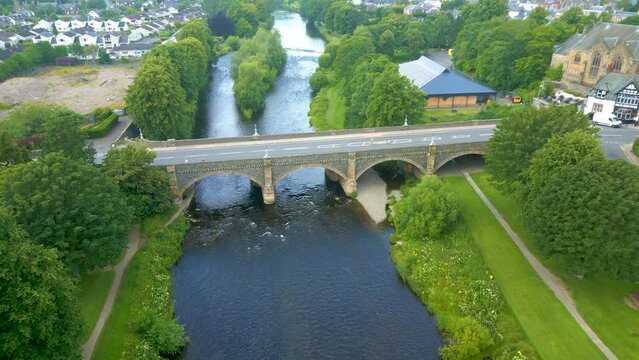 Aerial Drone shot flying northwest over the River Tweed towards the Tweed Bridge in the town of Peebles in the Scottish Borders.