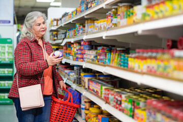 senior indian woman purchasing at grocery shop.