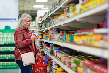 senior indian woman purchasing at grocery shop.