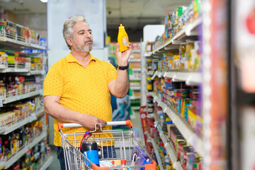 Senior indian man purchasing at grocery shop.