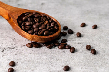 High angle shot of coffee beans in wooden spoon.