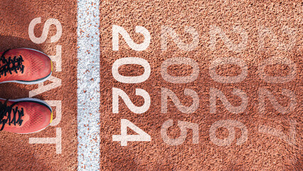 New year 2024 concept, beginning of success. Text 2024 written on asphalt road and male runner...