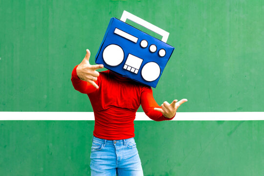 Faceless man with boombox showing rock sign