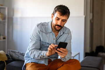 Young man using cellphone for work, social media or relaxation. Smart phone people concept.
