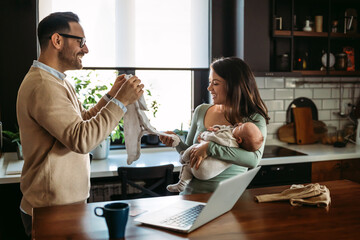 Online shopping. Young family with infant child purchasing things on internet together.