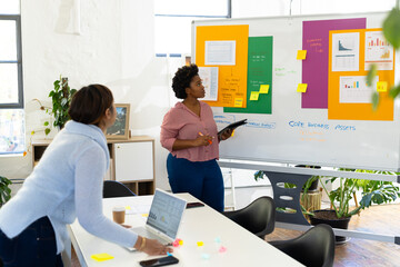 African american casual businesswoman making presentation at whiteboard in office