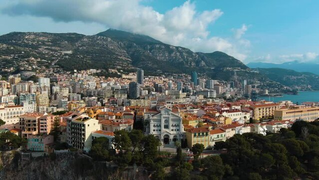 Beautiful cinematic aerial video of Saint Nicholas Cathedral and Monte Carlo cityscape. Flying over above Monaco Hercules harbour, port for Grand Prix de Monaco view from the sea on a sunny summer day