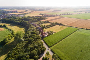 Luftaufnahme von einer Landschaft mit Feldern, Wald und Wiesen